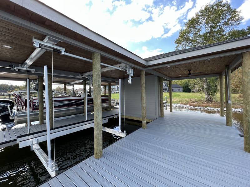 Boat lift slip and covered walkway along the dock, with a second roofline beyond