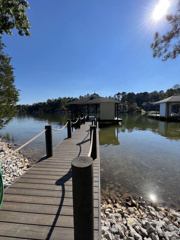 Long walkway to the covered dock on a sunny day, rocky shoreline in front