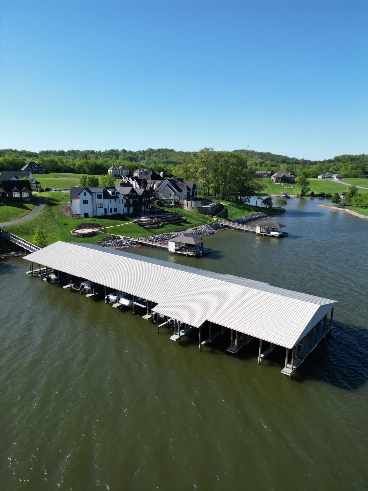 Aerial view of Lowe’s Ferry Marina on Fort Loudoun Lake in Louisville, TN: a long covered marina with a white metal roof and boat slips