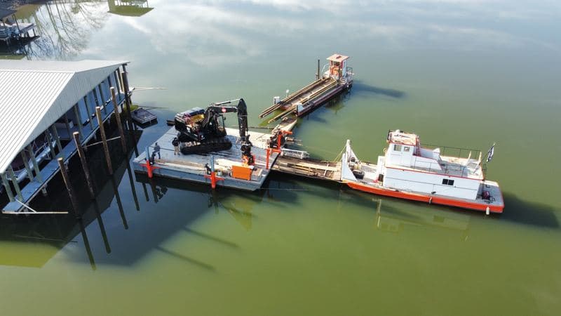 DOCK&DECK barge-mounted excavator and work boat working alongside the covered marina