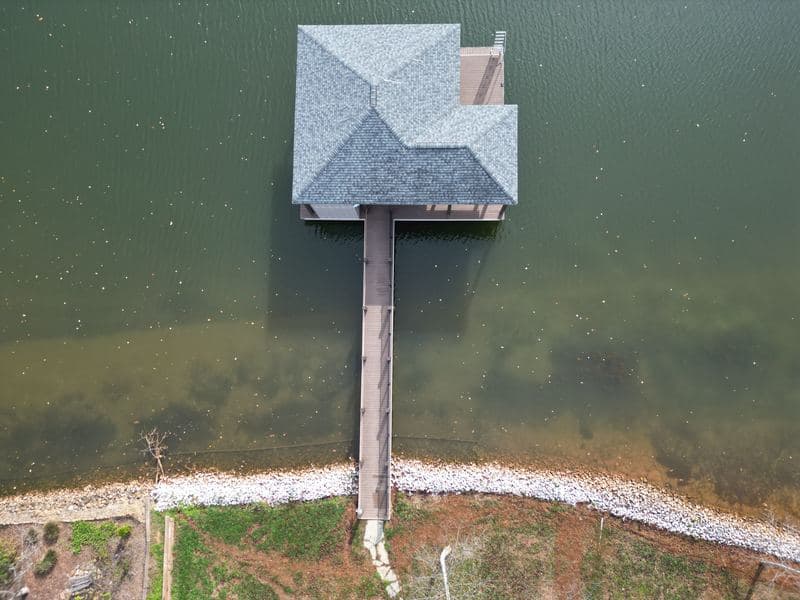 Top-down aerial of the covered dock and walkway extending from the shore