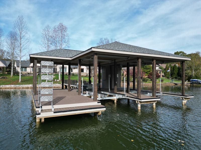 Open-sided covered dock with boat slips and lifts on the water