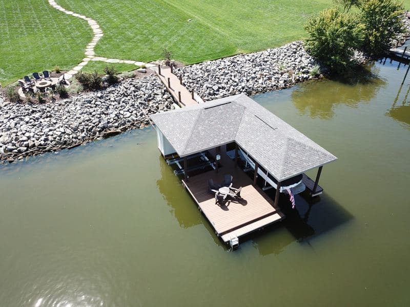 Aerial view of the covered dock and walkway off a rip rap shoreline