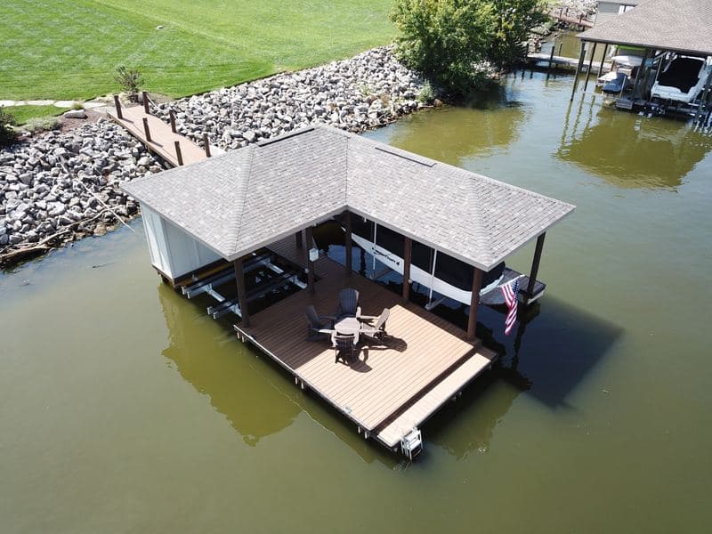 Aerial of the covered dock lounge deck with seating, lawn beyond